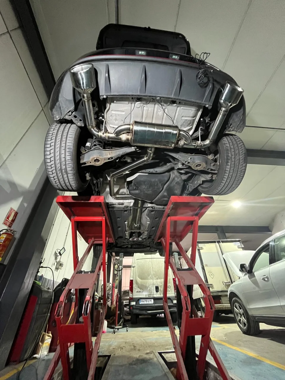 Sistema de escape de doble salida instalado en un coche elevado